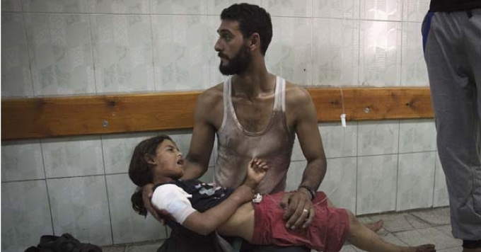 01_A_Palestinian_man_holds_a_girl_injured_in_an_Israeli_shelling